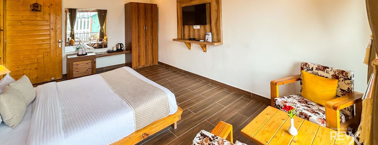 Resort room with sloping wooden ceiling, twin beds, and rustic yet stylish decor at Corbett Nirvana Resort.
