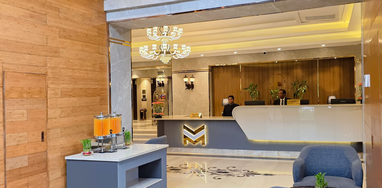 The corridor at the lobby of The Meriton featuring the reception desk in the front with the receptionists standing behind the desk.