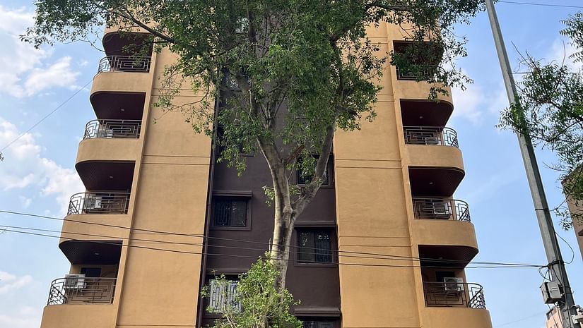 A front view of the hotel with a large tree in front and a sky in background at VITS Select Kharadi, Pune.