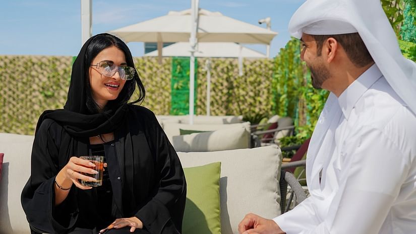 An arabic couple speaking to each other in an al fresco seating at La Patio - La Maison Hotel, Doha
