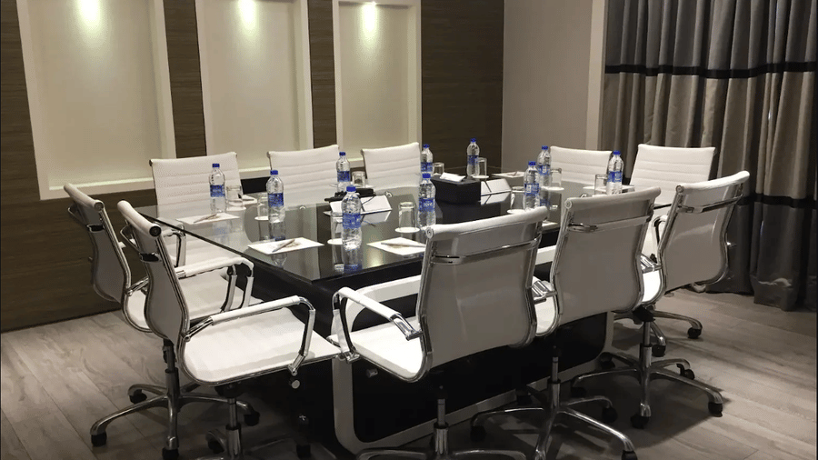A boardroom at Adamo Empressa with official chairs and a table.