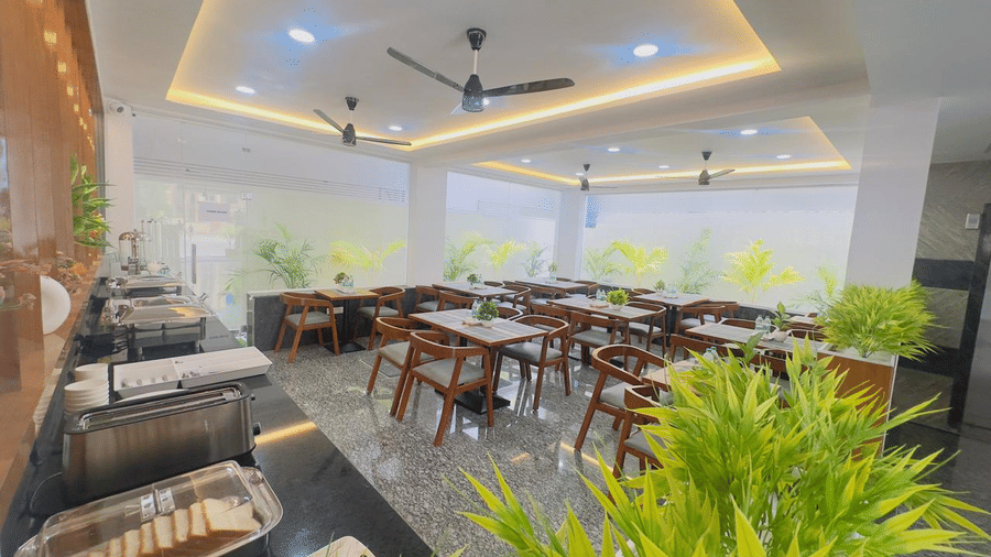 Restaurant dining hall with tables, chairs and a buffet serving area | Hotel Aurora Bliss