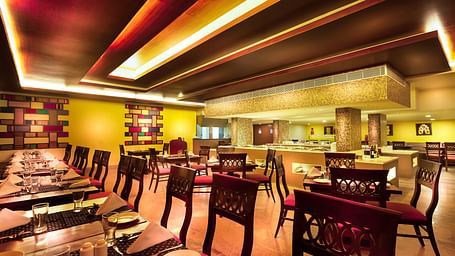 An image of a dining space with tables and chairs at Regency Madurai by GRT Hotels