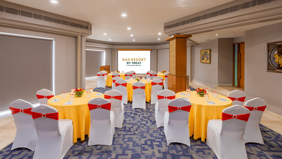 A well-lit meeting room at Ras Resort by Treat, Silvassa, with round tables set up for corporate meet