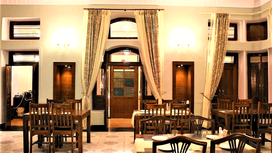Hotel Devnadi, Haridwar | A dining space with chairs, tables, and a fan.