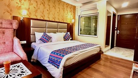 full view image of the superior room featuring a double bed and the entrance of the room - ZENQ SIGNATURE INN, MCLEODGANJ