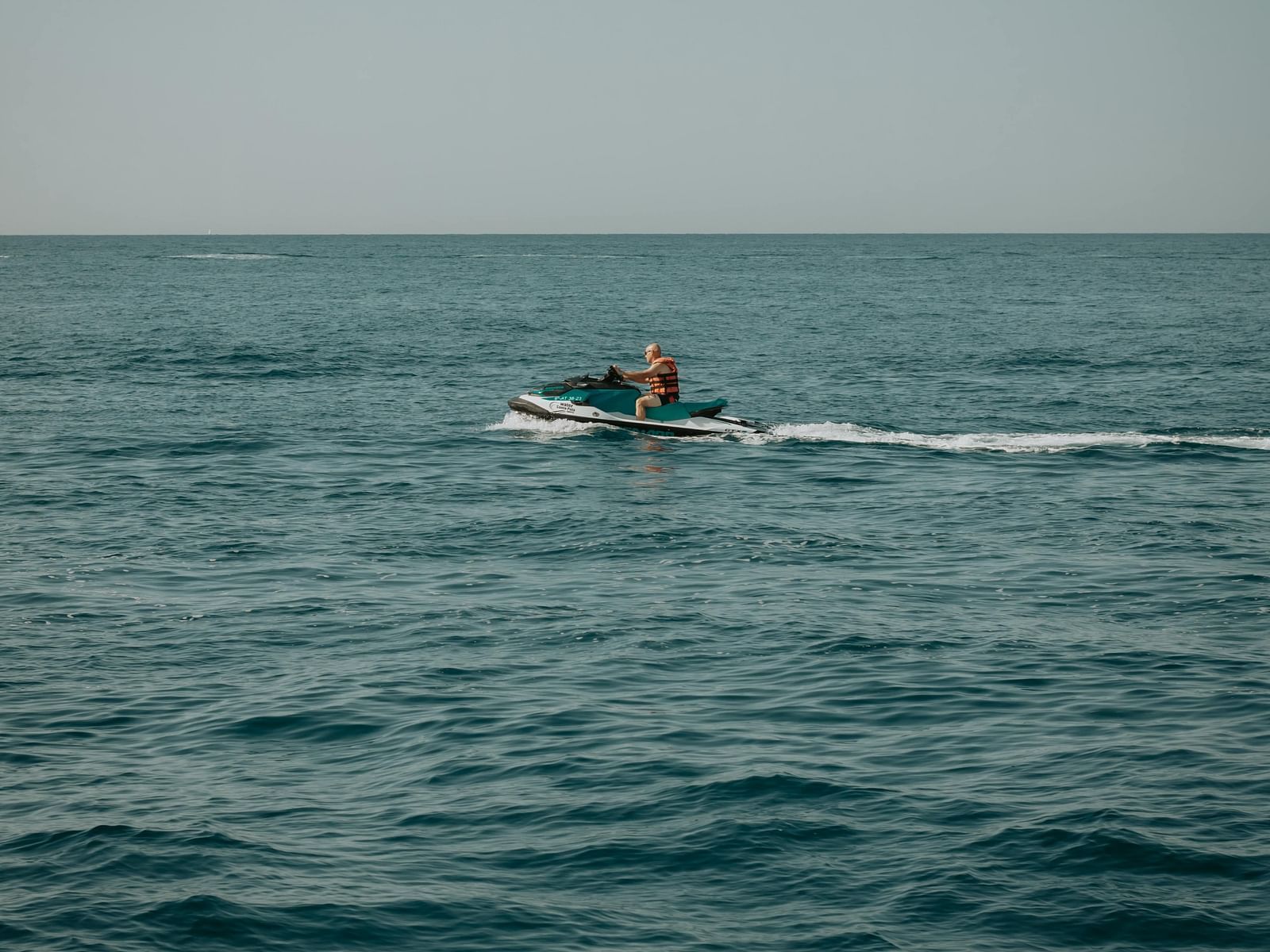 An image of a lake with a person on a speed boat