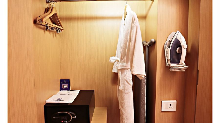 the wardrobe with an in-room safe and a bathrobe hanging offered at the Premium Room in Vizag 2