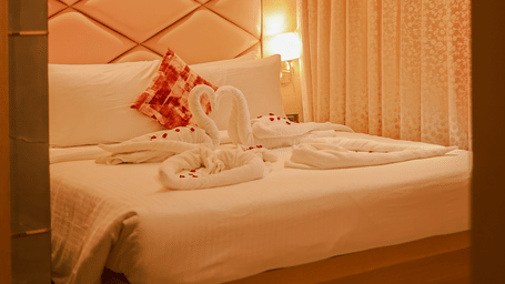 Bedroom with upholstered headboard and warm lighting at Hotel Mumbai House Digha, Airoli.