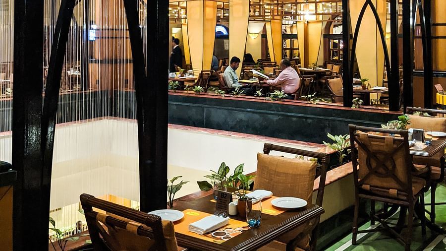 Night view of a restaurant's dining area featuring wooden furniture, decorative lighting, and a tranquil ambiance for evening meals.