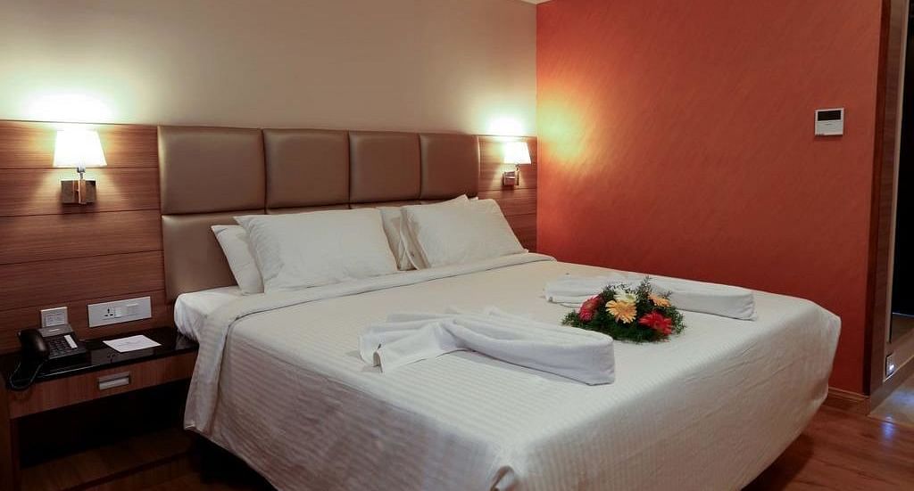Close up view of room with flower arranged on the bed wit a side table at Fressotel Seetharam, Coimbatore