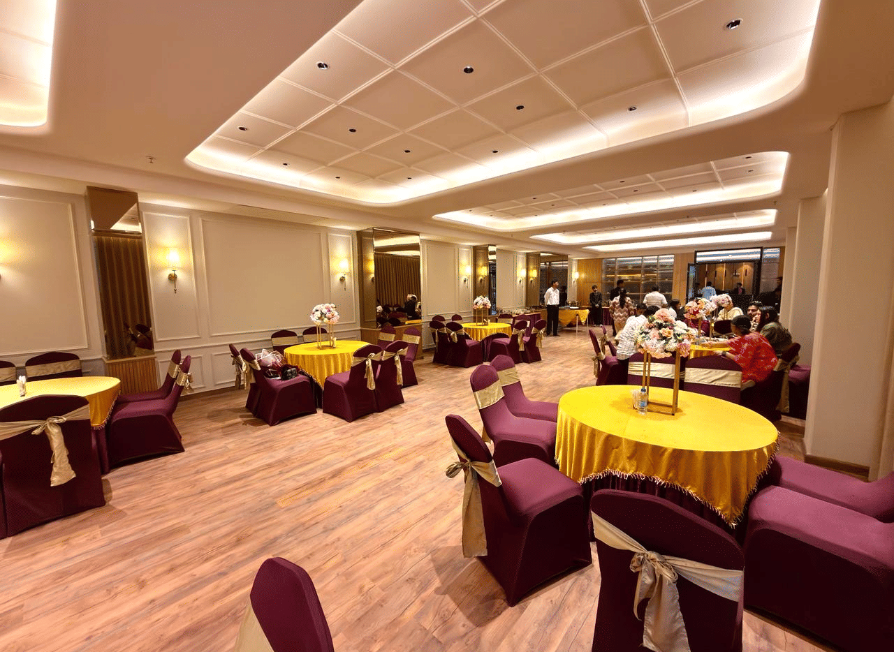 A banquet hall with round tables, neutral decor and soft lighting at Arnisa A Boutique Hotel
