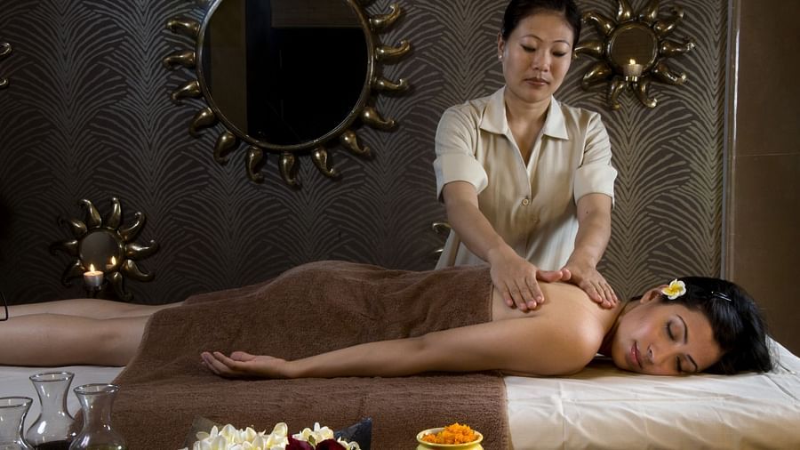 A woman getting a massage from a masseuse at Aruna spa - Heritage Village Resorts & Spa, Manesar
