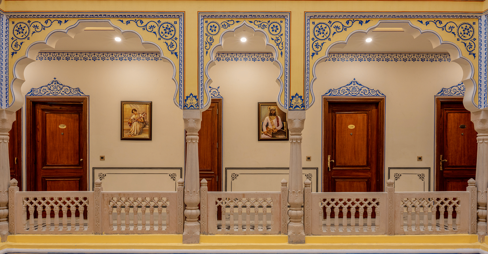 a beautiful corridor with pillars painted in miniature style painting - Brij Castle, Jaipur