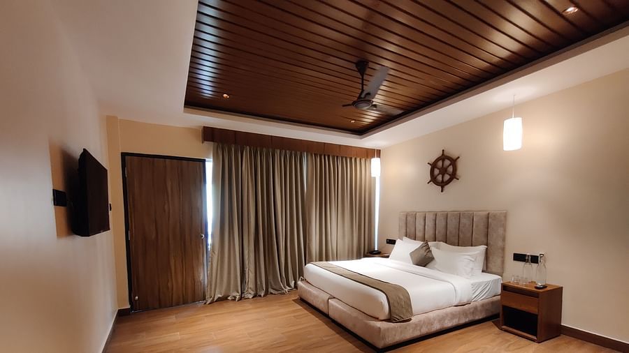 Side view of the room showcasing the veranda with sliding glass doors and greenery