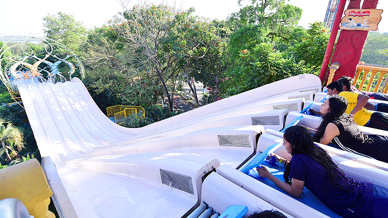 Water Kingdom - a group people about to ride the WHAT A COASTER slide