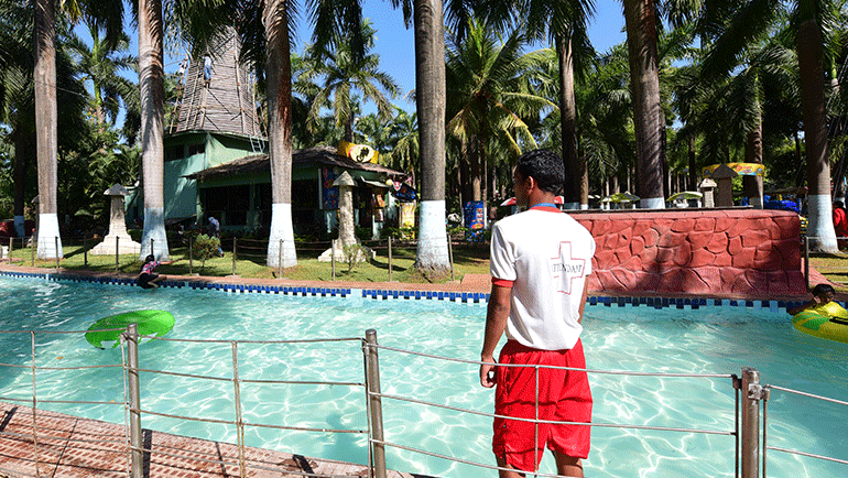 A life guard standing by a pool of water during daytime at our water par - Water Kingdom