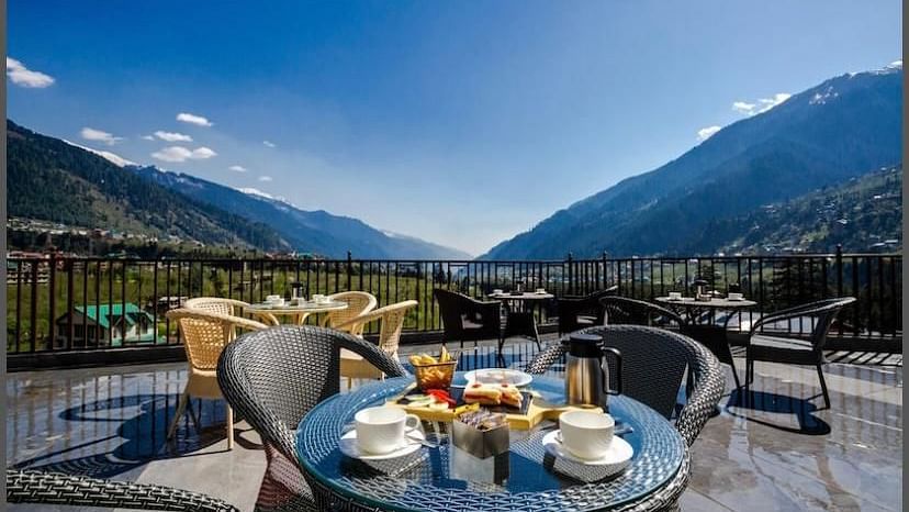 Image of the outdoor seating area at the resort overlooking the hills on a bright day | DLS La Serene Manali