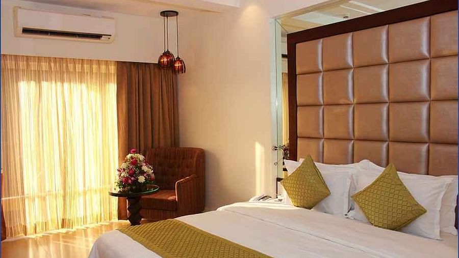 Image of a room with a bed and window on the side at Calux Grand Inn, Calangute.