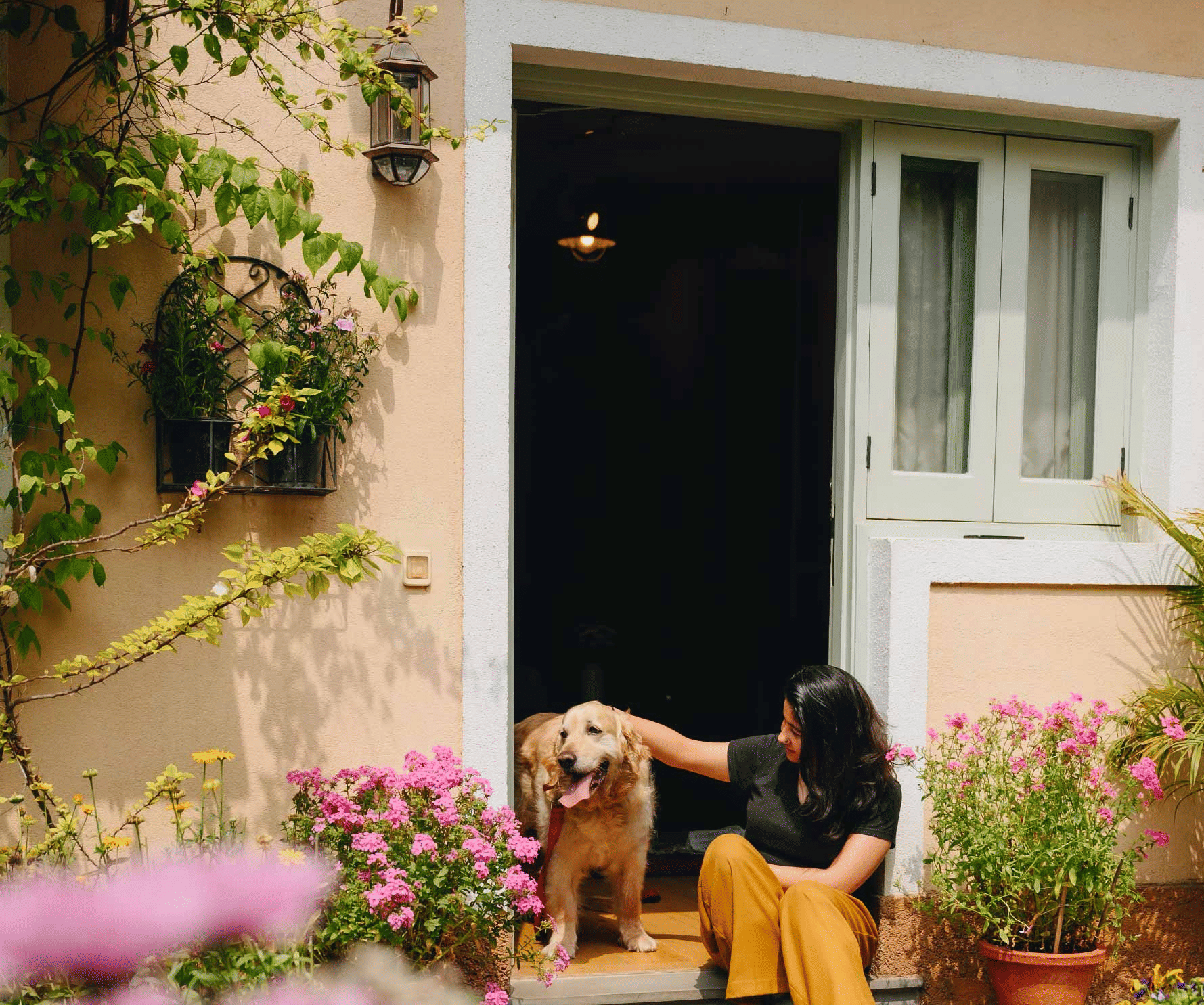 A woman petting a dog in front of the door of Karma Chalets.