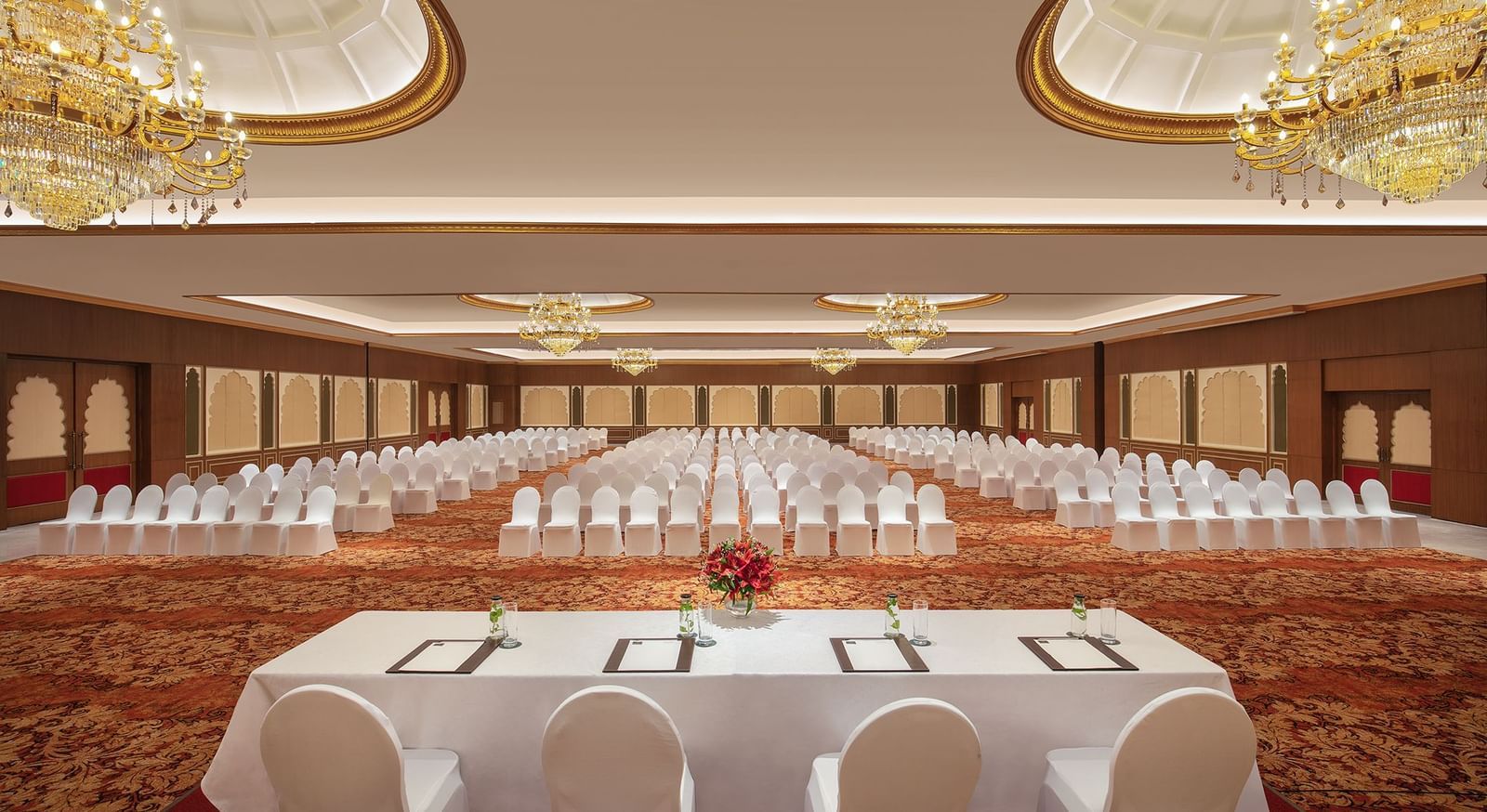 An image of a ballroom in Mahablipuram with chandeliers, carpeted floors and chairs arranged in a theatre style arrangement - Kaldan Samudhra Palace
