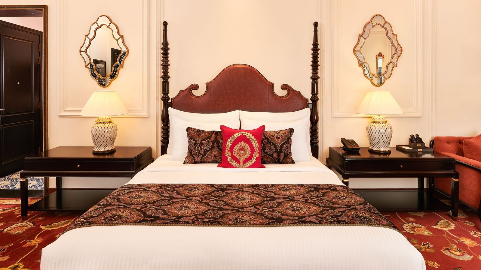 Ornate king-sized bed with vintage lamps and rich bedding at MAYFAIR Tea Resort, Siliguri