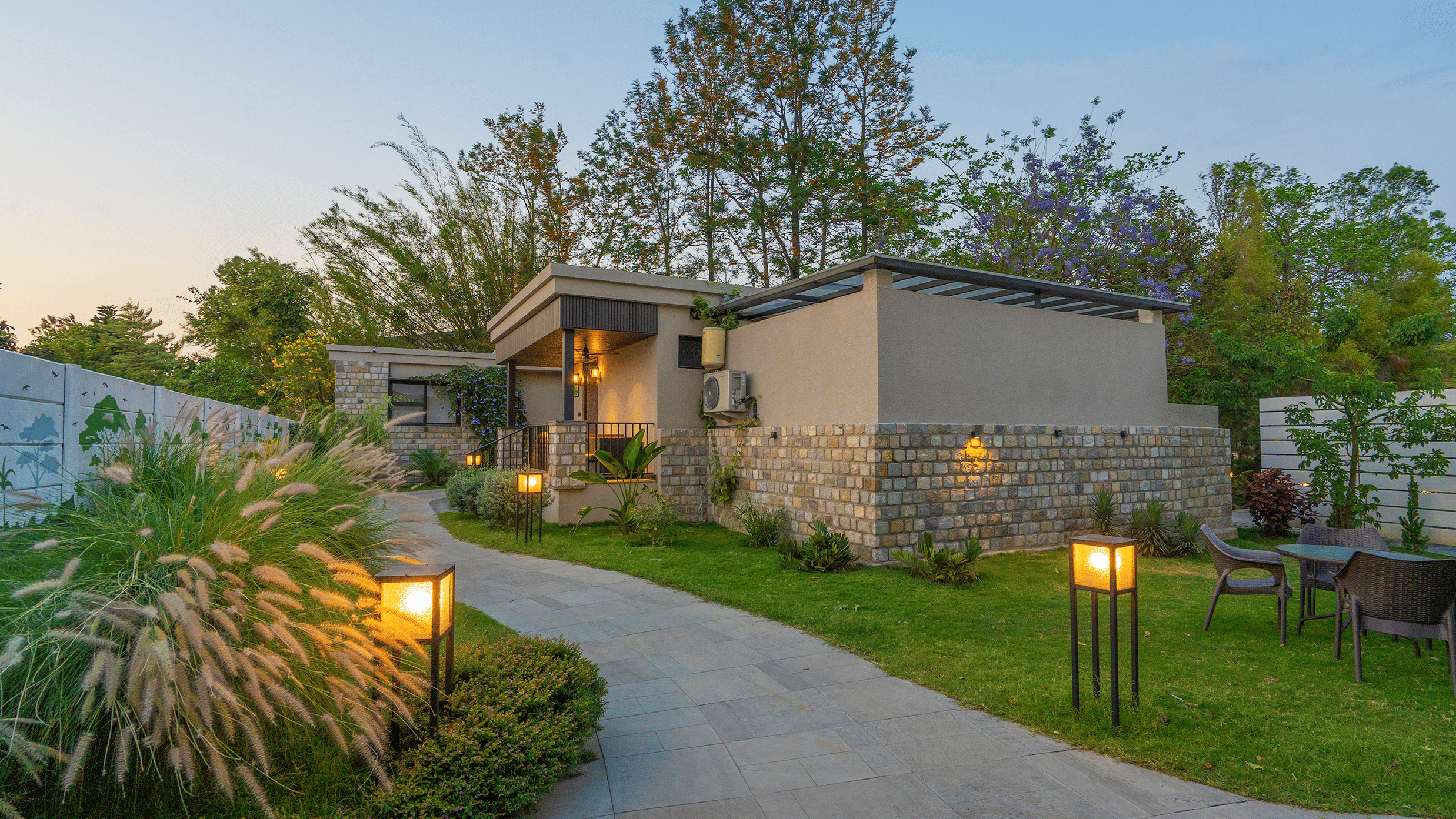 A paved pathway leading towards buildings in a landscaped area  at The Golden Tusk, Jim Corbett