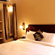 A room with a large bed, spreads, pillows, and lights. | Hotel Devnadi, Haridwar