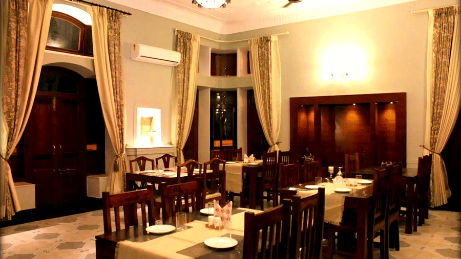 Hotel Devnadi, Haridwar | A dining space with chairs, tables, and a fan.