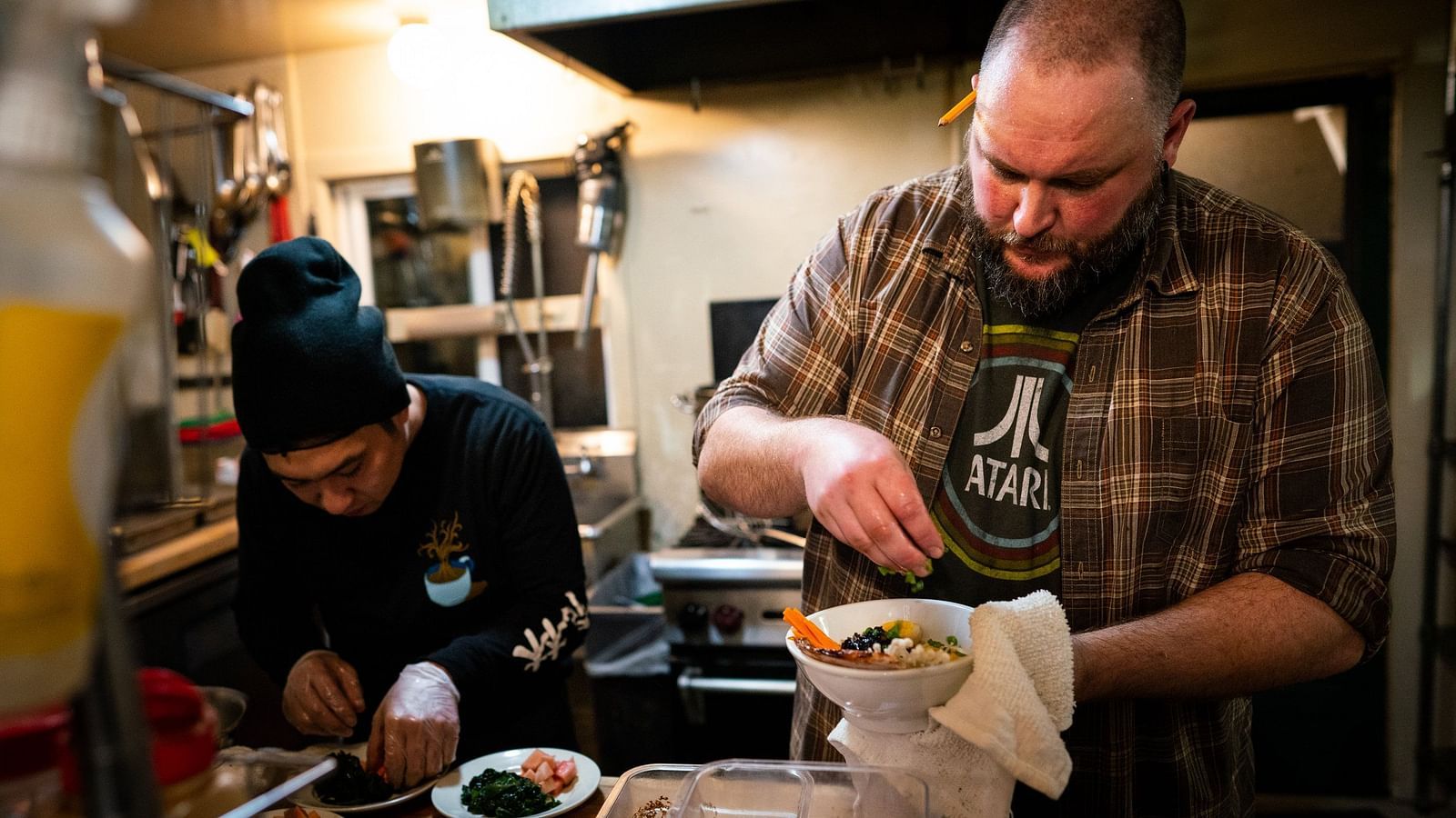 Two people in the frame, One man with a bowl in his hand.