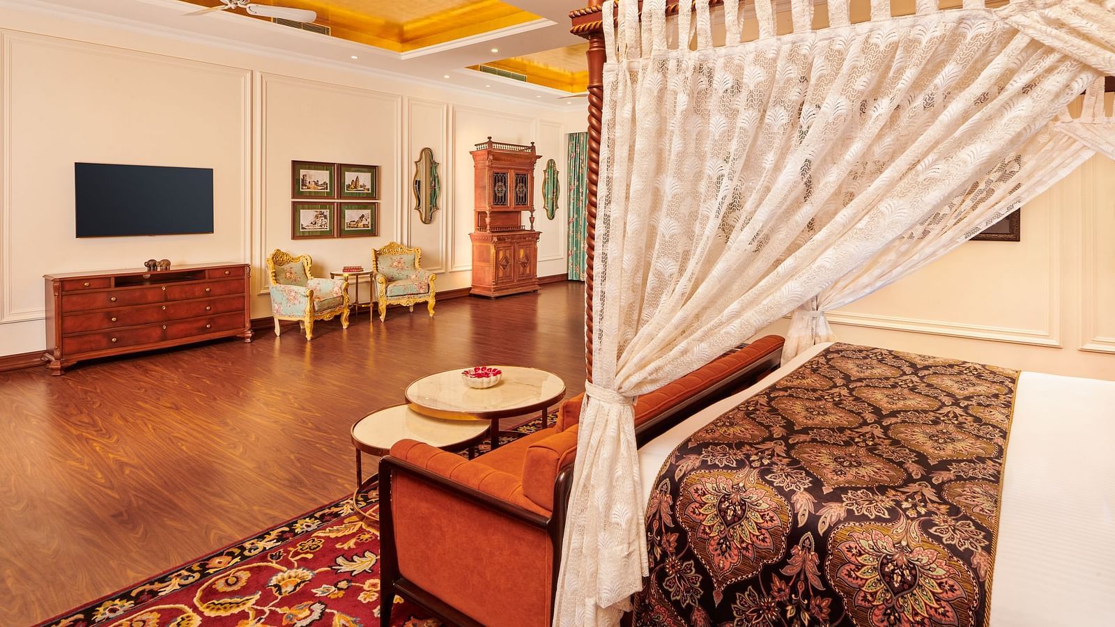 Luxurious suite with white canopy bed and spacious wooden flooring.