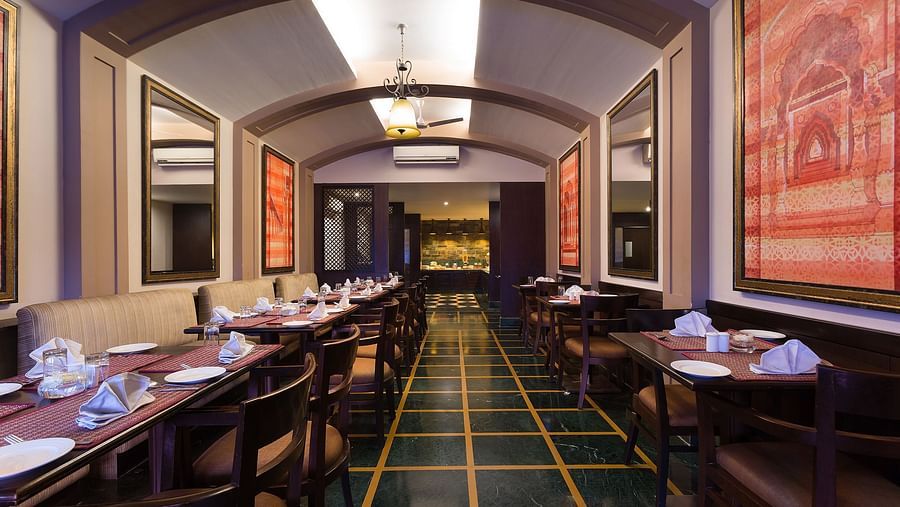A modern and elegant restaurant interior with dark wood accents and marble flooring.