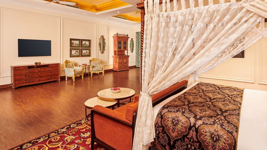 Luxurious suite with white canopy bed and spacious wooden flooring.