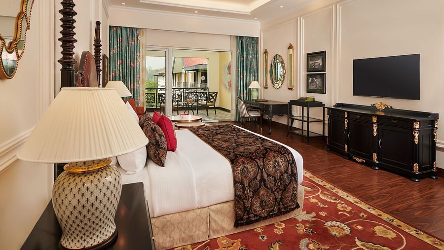 Classic bedroom with cosy lighting, elegant furniture, and large windows.