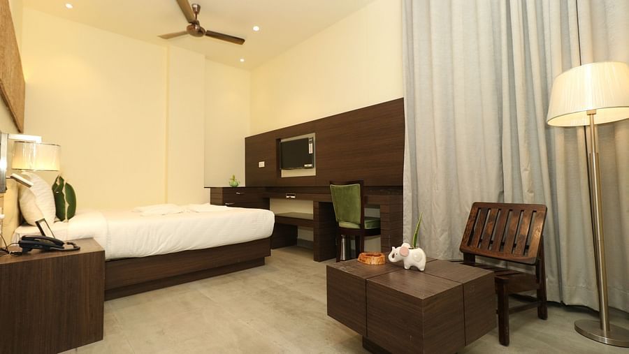 A modern hotel bedroom with a large white bed, bedside furniture, and contemporary wall decor, including a textured panel - Sea Hills Hotels, Sri Vijaya Puram (Port Blair)