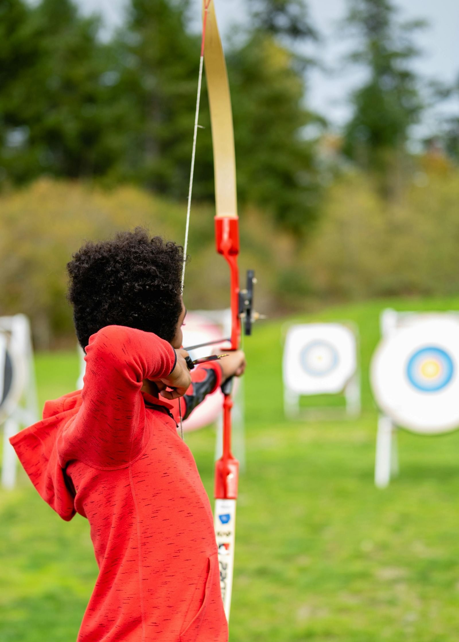 a child aiming an arrow to hit the target in the background - Caravela Beach Resort Goa