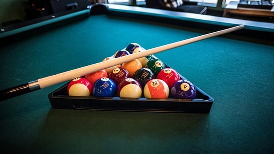 An image of billiard with balls and a stick