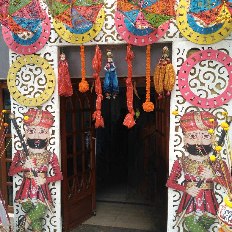 Vibrant and colourful entrance décor with traditional umbrellas and floral designs at Central Courtyard Boutique Hotel.
