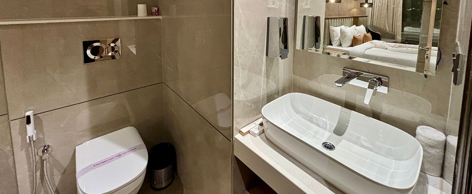 Modern bathroom with a large mirror, sink, and glass shower enclosure