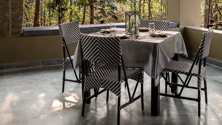 A table with couple of chairs at Dining at Saccharum Safari Lodge, Balaghat