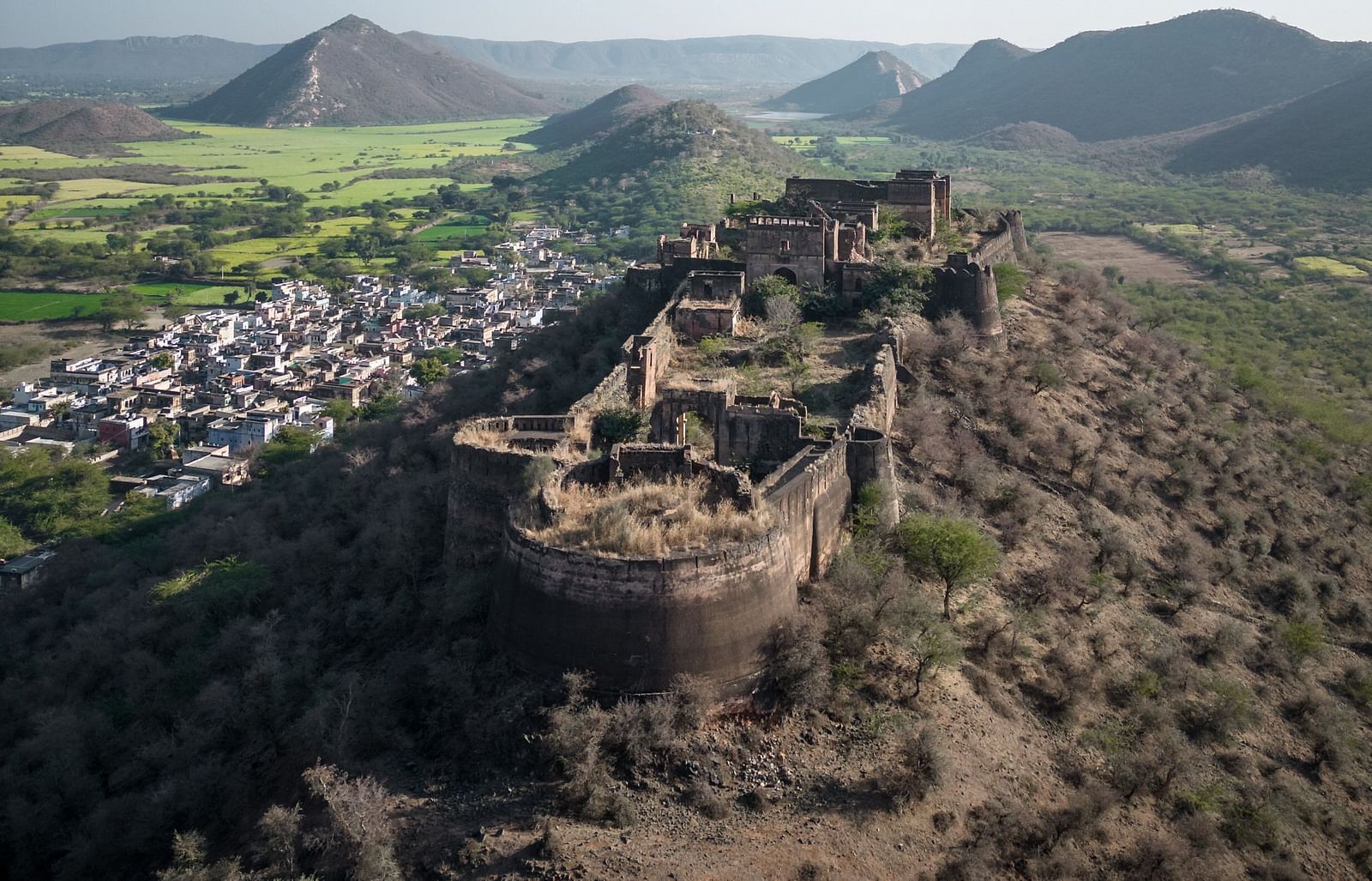 An aerial image of a fort with the backdrop of mountains