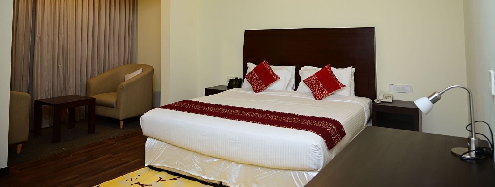 A double bed with red blanket and red pillow covers in the Executive Suite at Sterling Keys by TGI 4