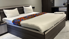 A side angle shot of the hotel bedroom with a large bed and ambient lighting at VITS Select Kharadi, Pune.