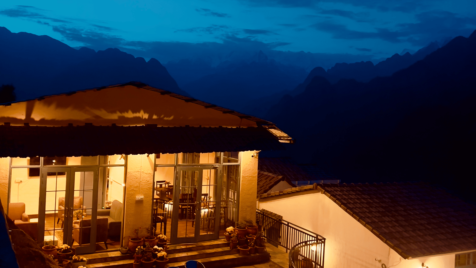 Cosy outdoor dining area lit up at dusk with mountain views at Faraway Cottages, Auli.