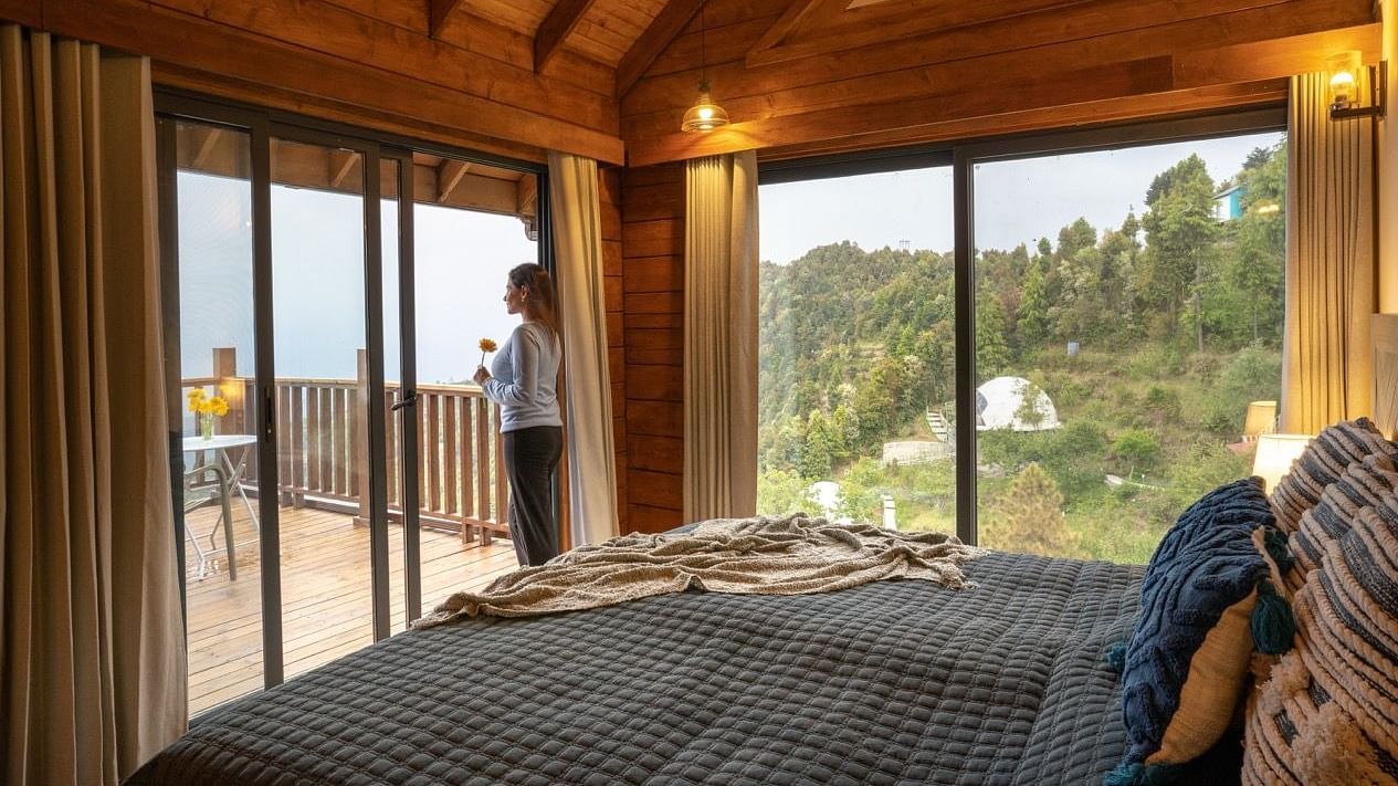 An image of a person staring at the view from a room at avalon cottages