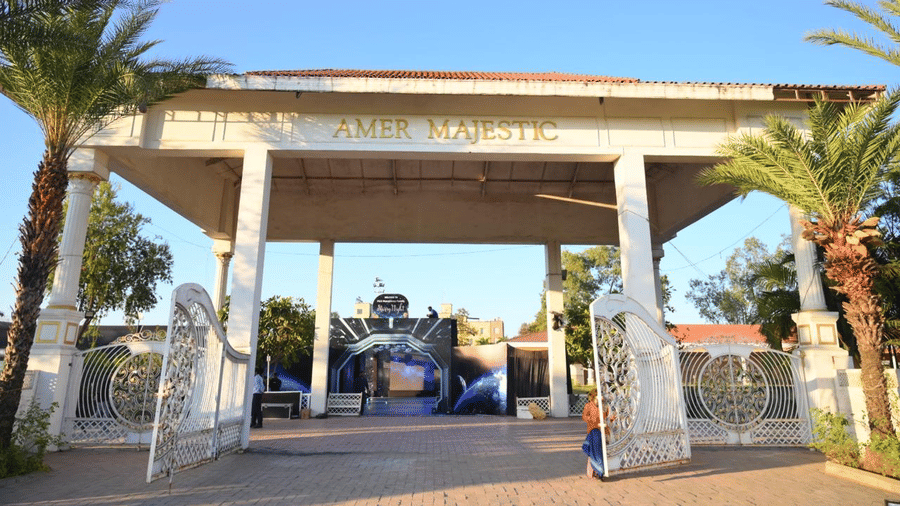 An entrance gateway with pillars, an open driveway, and event signage placed near the walkway.