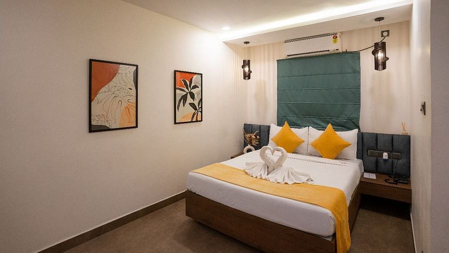 A well-lit room featuring a double bed with pillows and minimalist artwork on the walls at Hotel Kyzen Smartstays – Smart, Reliable, Kyzen