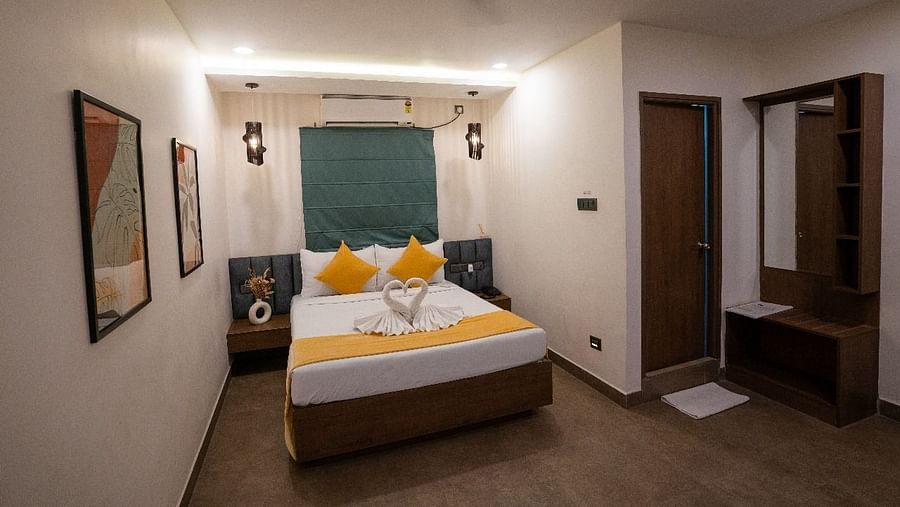 A corner view of the room showing a double bed, stylish wall art, and warm lighting at Hotel Kyzen Smartstays – Smart, Reliable, Kyzen