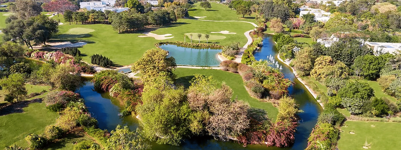 Aerial view of a golf course and surrounding trees at Karma Lakelands.