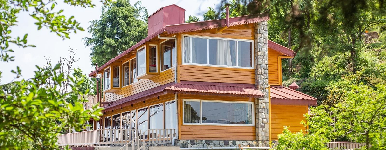 An image of a cottage with stairs and balconies at each floor surrounded by trees everywhere -  Avalon Cottages, Kanatal